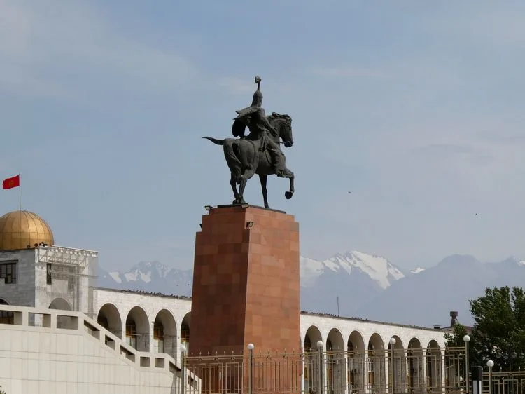 Estatua de Manás a caballo con las montañas de fondo en la ciudad de Biskek