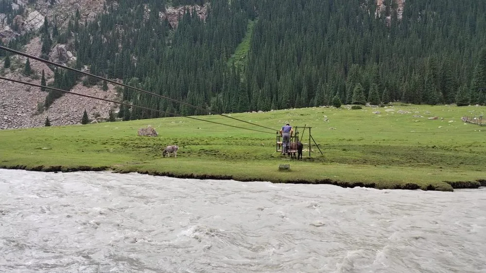 Cruce con cables de un río Haciendo trekking en Kirguistán